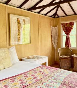 a bedroom with a bed and a chair and windows at Gatherwild Ranch in Germantown