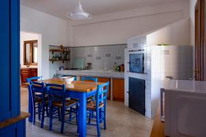 a kitchen with a wooden table and blue chairs at Villa Santa Lucia in Noto