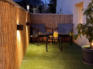 a small patio with two chairs and a table at Le Bain des VioIettes - Grand jacuzzi privatif in Dole