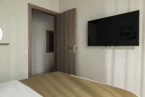 a bedroom with a bed with a flat screen tv on the wall at Sakis 2 in Polychrono