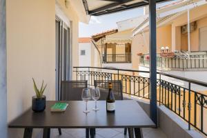 a table with two wine glasses on a balcony at Sakis 2 in Polychrono