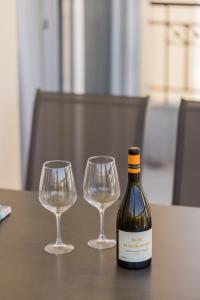 a bottle of wine and two wine glasses on a table at Sakis 2 in Polychrono