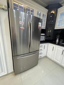 a stainless steel refrigerator in a kitchen with white cabinets at Residencial Paradise in San Francisco de Macorís