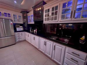 a kitchen with white cabinets and a sink and a refrigerator at Residencial Paradise in San Francisco de Macorís