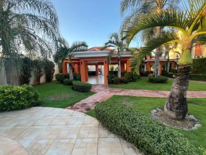 a palm tree in front of a house at Residencial Paradise in San Francisco de Macorís
