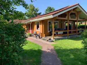 a wooden house with a porch and a bench at Just Relax in Gramsbergen