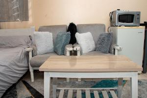 a living room with a couch and a table with pillows at Delore suits in Ongata Rongai 