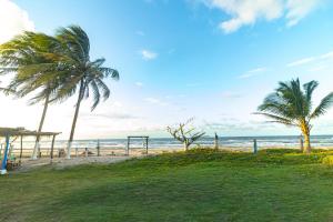 a beach with two palm trees and the ocean at Hostal Rudy's Beach in Puerto Cortés