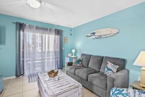 a living room with a couch and a table at Spacious 2BR Condo with Pool Across from the Beach in Gulf Shores