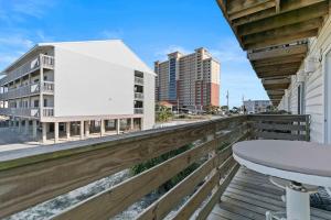 a balcony with a table and a building at Spacious 2BR Condo with Pool Across from the Beach in Gulf Shores +15 photos