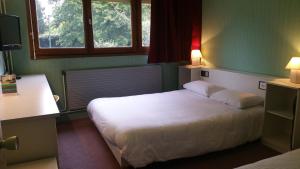 a bedroom with a white bed with two lamps at Promotel in Saint-Jean-de-Braye