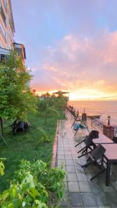 a row of tables and benches next to the ocean at My White Residence in Trabzon