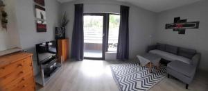 a living room with a couch and a television at Ferienwohnung Hexenhäusla in Gößweinstein