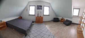 a bedroom with a bed and a dresser and windows at Ferienwohnung Hexenhäusla in Gößweinstein