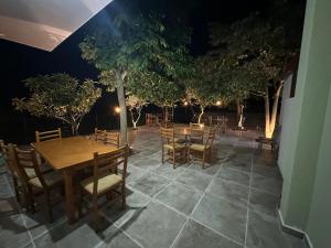 a table and chairs on a patio at night at Hotel Bar Restorant Bilo in Këlcyrë +23 photos
