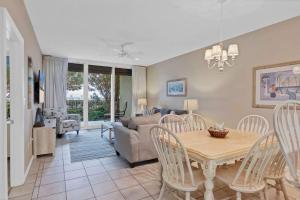 a dining room and living room with a table and chairs at 3BR 4BA Ground Floor Gulf Getaway in Gulf Shores