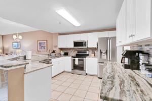 a large kitchen with white cabinets and appliances at 3BR 4BA Ground Floor Gulf Getaway in Gulf Shores