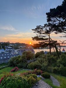 a sunset over a marina with a tree and flowers at Chez Billie et Moon in Landéda