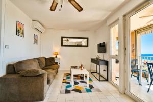 a living room with a couch and a table at Mer et plage Standing Presta in Cannes