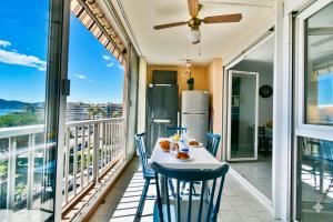 a balcony with a table and chairs and a refrigerator at Mer et plage Standing Presta in Cannes +7 photos