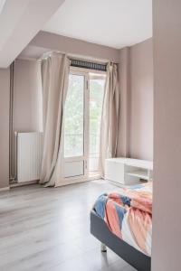 a bedroom with a bed and a large window at The Hague appartment in The Hague