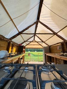 a group of stoves in a tent with a view of a field at Hinton land glampsite in Peterchurch