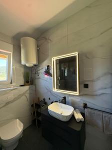a bathroom with a sink and a toilet at Apartments Angela Rab in Supetarska Draga +44 photos