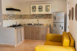 a kitchen with a yellow couch and a refrigerator at Casa Crespo in Cartagena de Indias