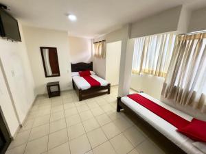 a room with two beds and a tv in it at Hotel Tucan Pereira in Pereira