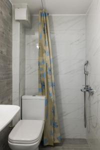 a bathroom with a toilet and a shower curtain at Sakis in Polychrono
