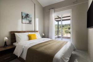 a bedroom with a bed with yellow pillows and a window at Sakis in Polychrono +5 photos