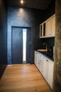 a kitchen with a black door and a wooden floor at Ascent Lodge -Jacuzzi si Panoramic View in Petreasa