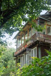 an old house with a balcony on the side of it at Aloha Riverside in Kasol +26 photos