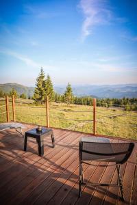 a bench and a table on a deck with a view at Ascent Lodge -Jacuzzi si Panoramic View in Petreasa