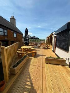 a deck with picnic tables and umbrellas on it at The Royal George Cottingham in Cottingham