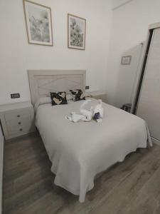 a bedroom with a large white bed with pillows at Apartamento Martina 1 in Mérida
