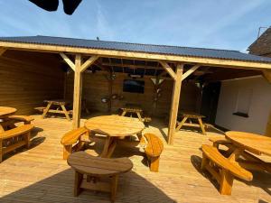 a deck with wooden tables and chairs and a pavilion at The Royal George Cottingham in Cottingham