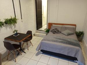 a bedroom with a bed and a table with chairs at Suíte aconchego in Domingos Martins