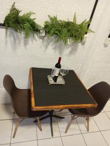 a bottle of wine on a table with two chairs at Suíte aconchego in Domingos Martins +7 photos