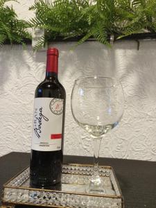 a bottle of wine sitting next to a wine glass at Suíte aconchego in Domingos Martins