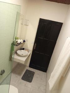 a bathroom with a black door and a sink at Suíte aconchego in Domingos Martins