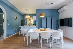 a dining room with blue walls and a white table and chairs at Villa Domina by Letstay in Giardini Naxos