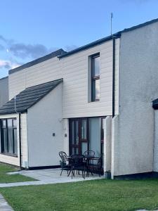 a building with a patio with tables and chairs at 39 Perran View Your Home Away from Home in Cornwall in St. Agnes