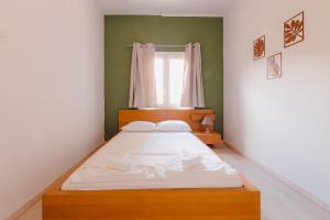 a bedroom with a large bed with white sheets at Zoumperi Summer House in Nea Makri