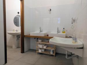 a bathroom with two sinks and a mirror at inScialla Hostel in Trapani