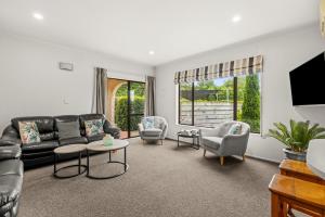 a living room with a black leather couch and chairs at Parkhill Lodge Villa in Hastings