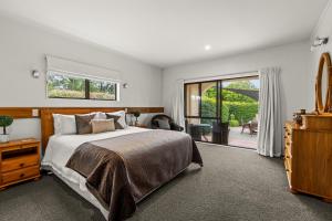 a bedroom with a large bed and a sliding glass door at Parkhill Lodge Villa in Hastings