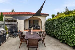 a patio with a table and chairs and a grill at Parkhill Lodge Villa in Hastings