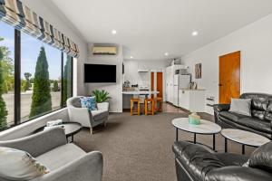 a living room with two couches and a tv at Parkhill Lodge Villa in Hastings