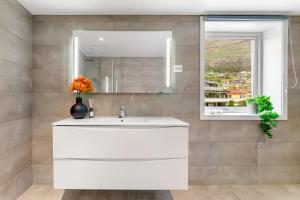 a bathroom with a white sink and a mirror at Stryn Apartments - City Center - Modern Suites in Stryn +41 photos